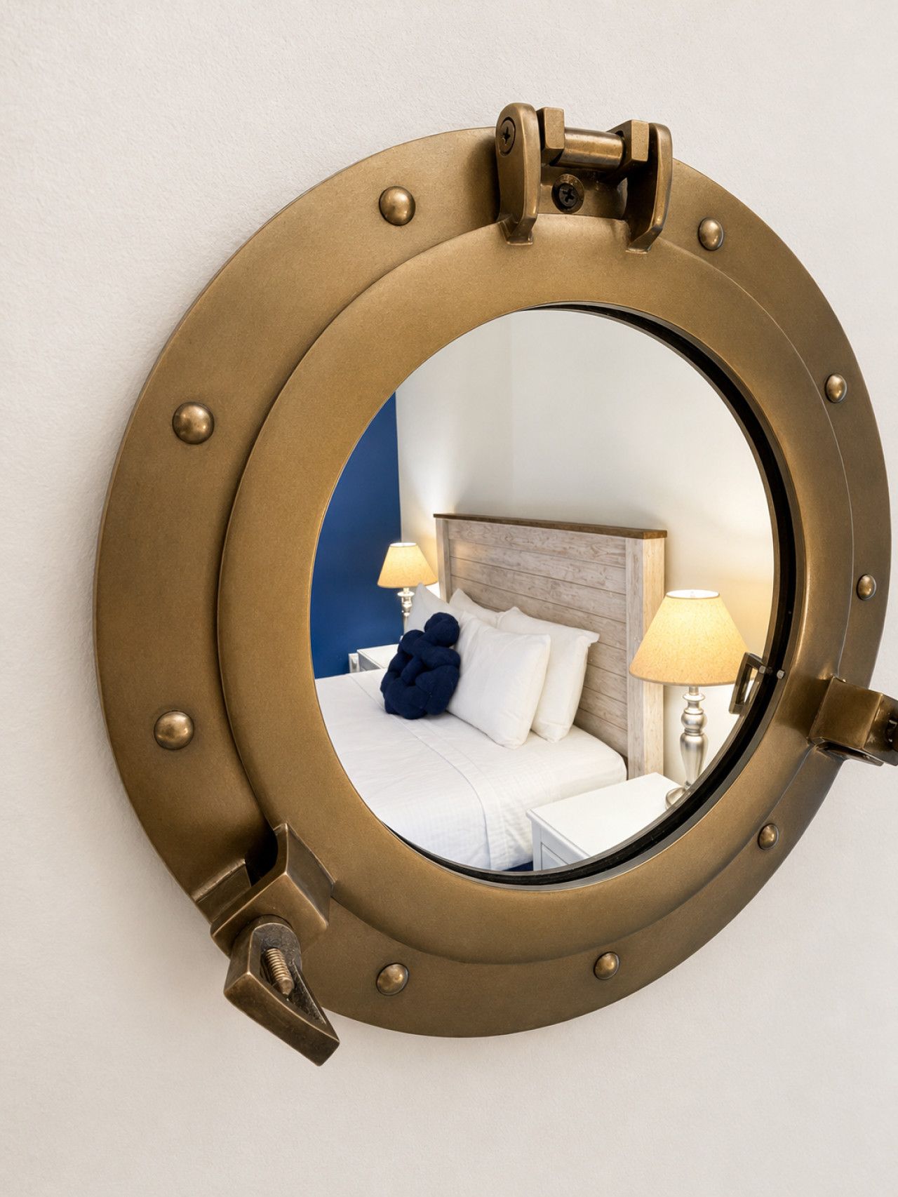 A circular mirror with a brass frame mounted on a wall.