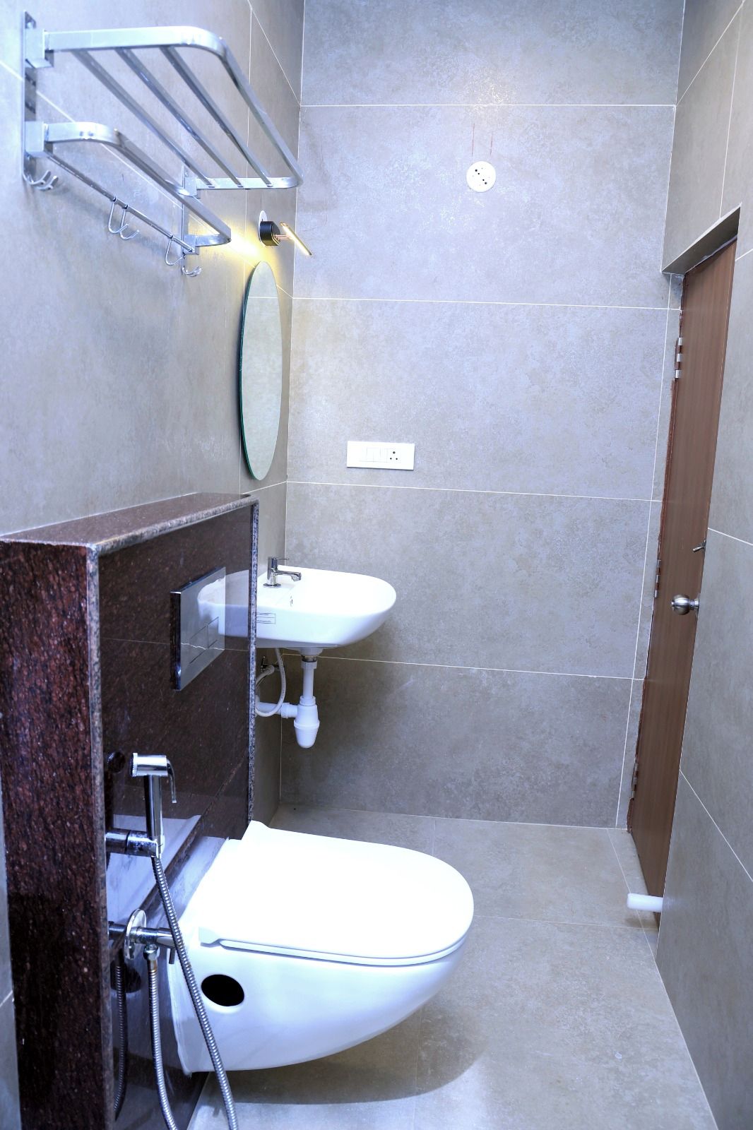 A bathroom with a toilet, two sinks, a mirror, and a towel rack.