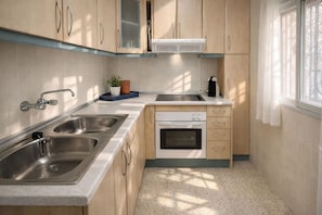 Cozinha compacta com duas pias, fogão e lava-louças.
