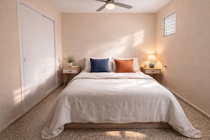 A bedroom with a bed, nightstands, a ceiling fan, a window with blinds, and a door. - LA MATA BEACH · Apartment with a view in La Mata (Torrevieja) for 4 people (La Mata)