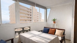 A room with a bed, a table, and a window with a view of buildings. - LA MATA BEACH · Apartment with a view in La Mata (Torrevieja) for 4 people (La Mata)