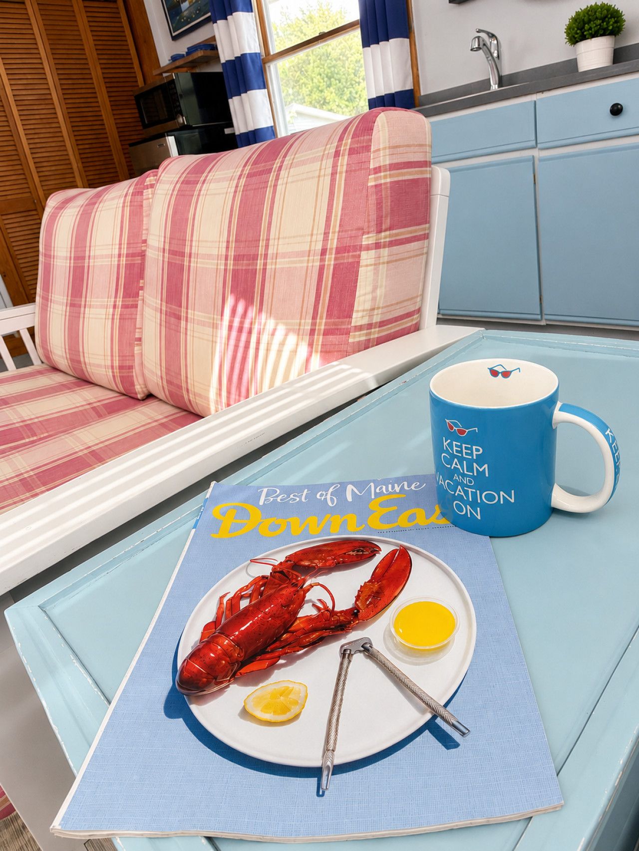 A dining table with a lobster dish, a mug, and a placemat with text.
