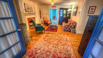 Una sala acogedora con chimenea, un tapete estampado y una puerta azul.
