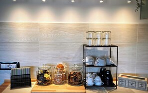 A kitchen area with a coffee station, including jars of tea, a coffee machine, and a shelf with teacups. - Apartment in a villa with free parking and a private garden. (Abruzzo)