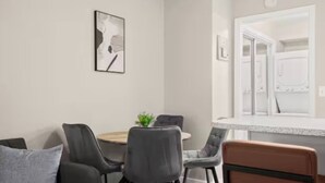 Un comedor con una mesa redonda, cuatro sillas y una planta pequeña.
