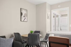 Un coin repas avec une table ronde, quatre chaises et une petite plante.