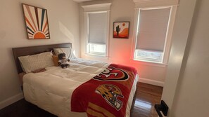 A bedroom with a bed, pillows, a teddy bear, a blanket, and two windows with blinds. - 3-bedroom house in delightful Braintree with hot tub and movie screening room (Braintree)