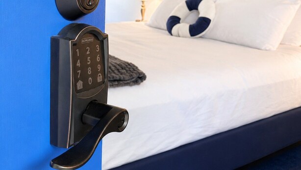 Ein Hotelzimmer mit Bett, einem wandmontierten Schlüsselfeld und einem Deckenventilator.