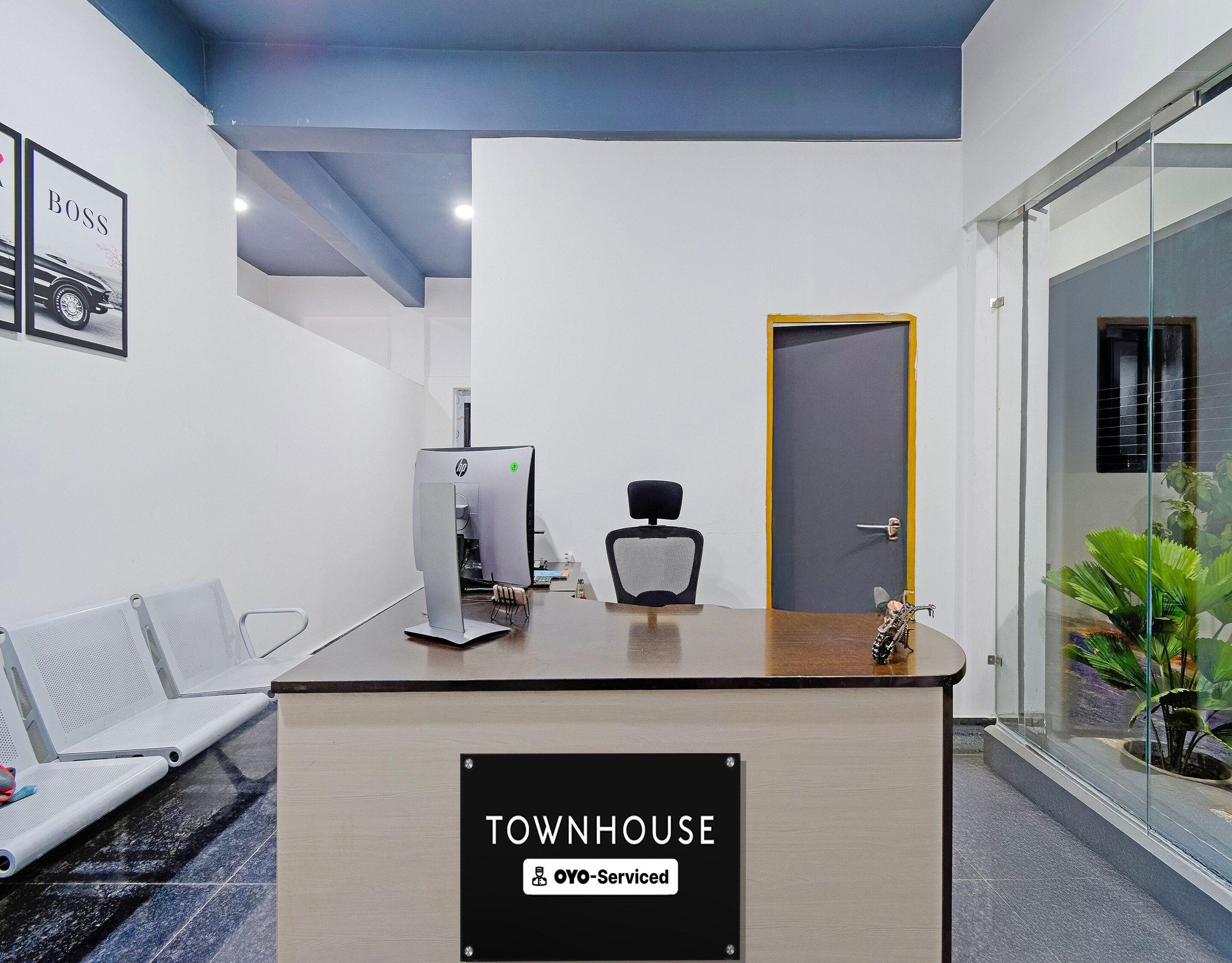 A reception desk with a sign reading 'TOWNHOUSE OYO-Serviced.'