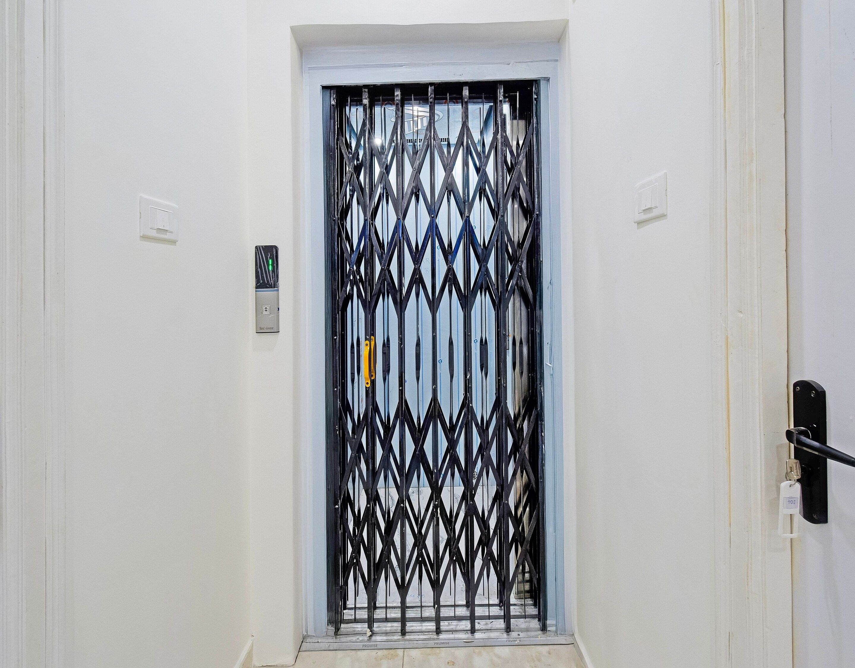 A white door with a black metal security gate.