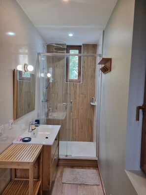 A modern bathroom with a glass shower enclosure, a wooden vanity, and a mirror with lights. - L'Écrin d'Orelle Apartment – 2 Bedrooms, Mountain Views, Near Gondola (Orelle)