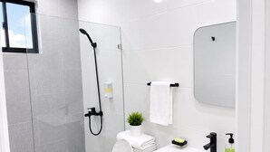 A modern bathroom with a toilet, shower, and sink. - residencial los garcia la romana  (La Romana)