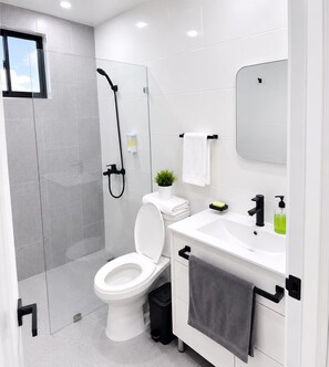 Un baño moderno con inodoro, ducha y lavabo.