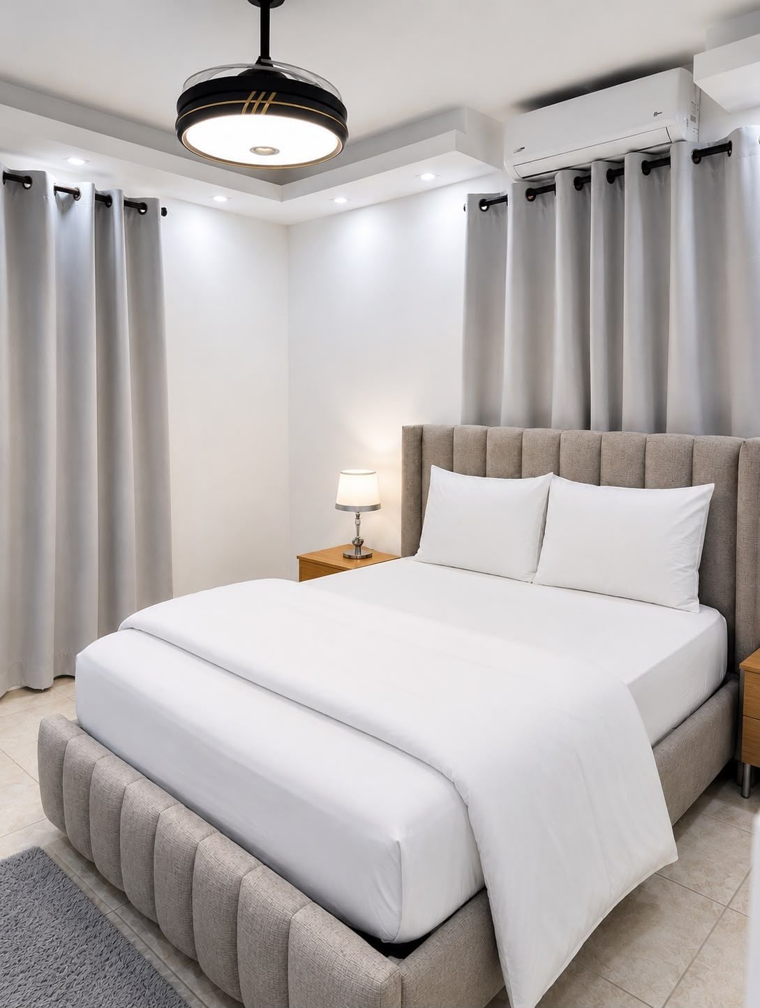 Une chambre moderne avec un grand lit, une table de chevet avec une lampe et un appareil de climatisation.