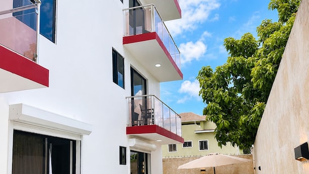 A modern building with a swimming pool, outdoor seating, and a barbecue area. - residencial los garcia la romana  (La Romana)