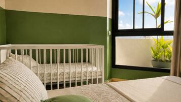 Une chambre avec un berceau, un lit et une fenêtre donnant sur une plante.