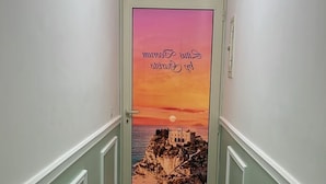 Un pasillo con una puerta que ofrece vista al atardecer y un mensaje.