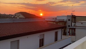 Una azotea con vistas a la puesta de sol sobre un área residencial.