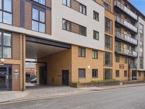 A multi-story residential building with a covered entrance, a visible fire hydrant, and a street in front. - Stylish City Centre Living (Birmingham)