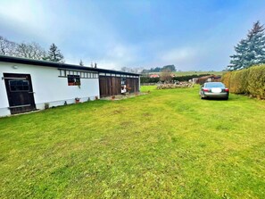 A residential property with a white exterior, a garage, and a car parked in the driveway. - Holiday Home Anna (Benz)