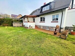 A house with a sloped roof, a stone foundation, and a wooden deck. - Holiday Home Anna (Benz)