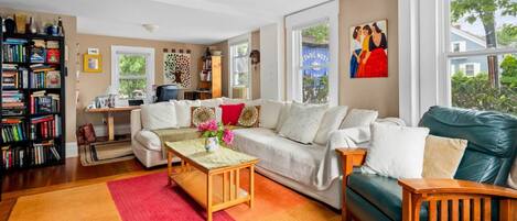 A living room with a sofa, coffee table, and a bookshelf.