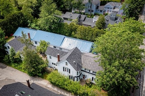 Una zona residencial con varias casas, incluyendo una casa blanca destacada con techo azul y una chimenea.