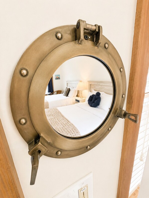 A circular mirror with a nautical design, mounted on a wall.