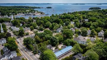An aerial view of a coastal town with residential areas, a church, and a marina with boats.