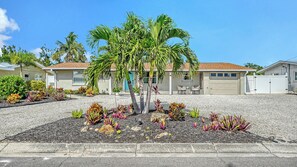 A residential area with houses, a palm tree, and a gravel driveway. - Water Views | Beach | Pool | Paddle Boards (Bradenton)