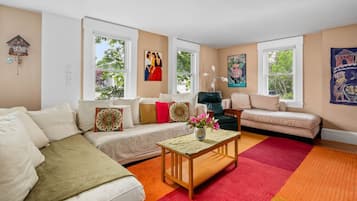 Una sala de estar con sofá, sillones, una mesa de centro y chimenea.