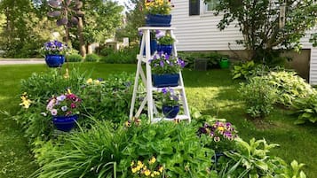 Un jardín con una escalera blanca y varios maceteros azules dispuestos en niveles.