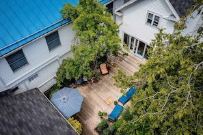 A residential property with a blue roof, a wooden deck, and a garden area with a patio and seating. - Towne Motel Camden Room #2 (Camden)