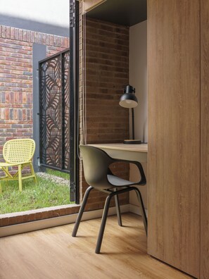 Un espacio de oficina moderno con escritorio, silla y lámpara.