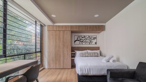 Quarto com cama, escrivaninha e cadeira.