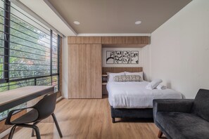 Un dormitorio con cama, escritorio y silla.