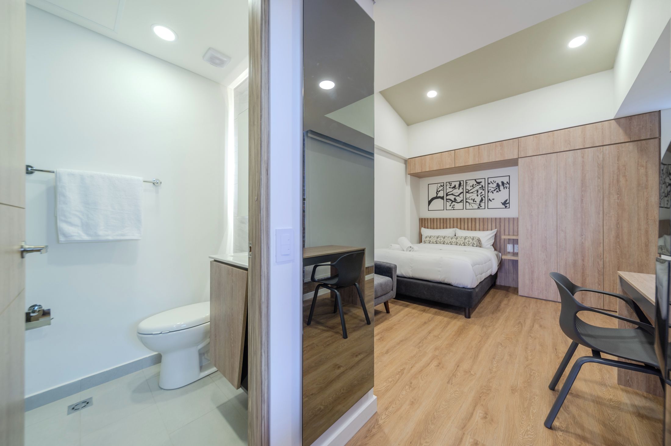 A modern bathroom with a toilet, a sink, and a towel rack.