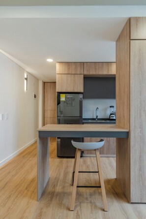 Una cocina moderna con refrigerador empotrado, un lavamanos y una encimera.