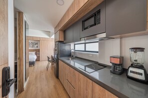 A modern kitchen with a built-in microwave, a coffee maker, and a blender. -  Sierra Madre Apartamentos (Bogotá)