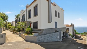 Um edifício moderno de dois andares com teto plano, grandes janelas e uma varanda.