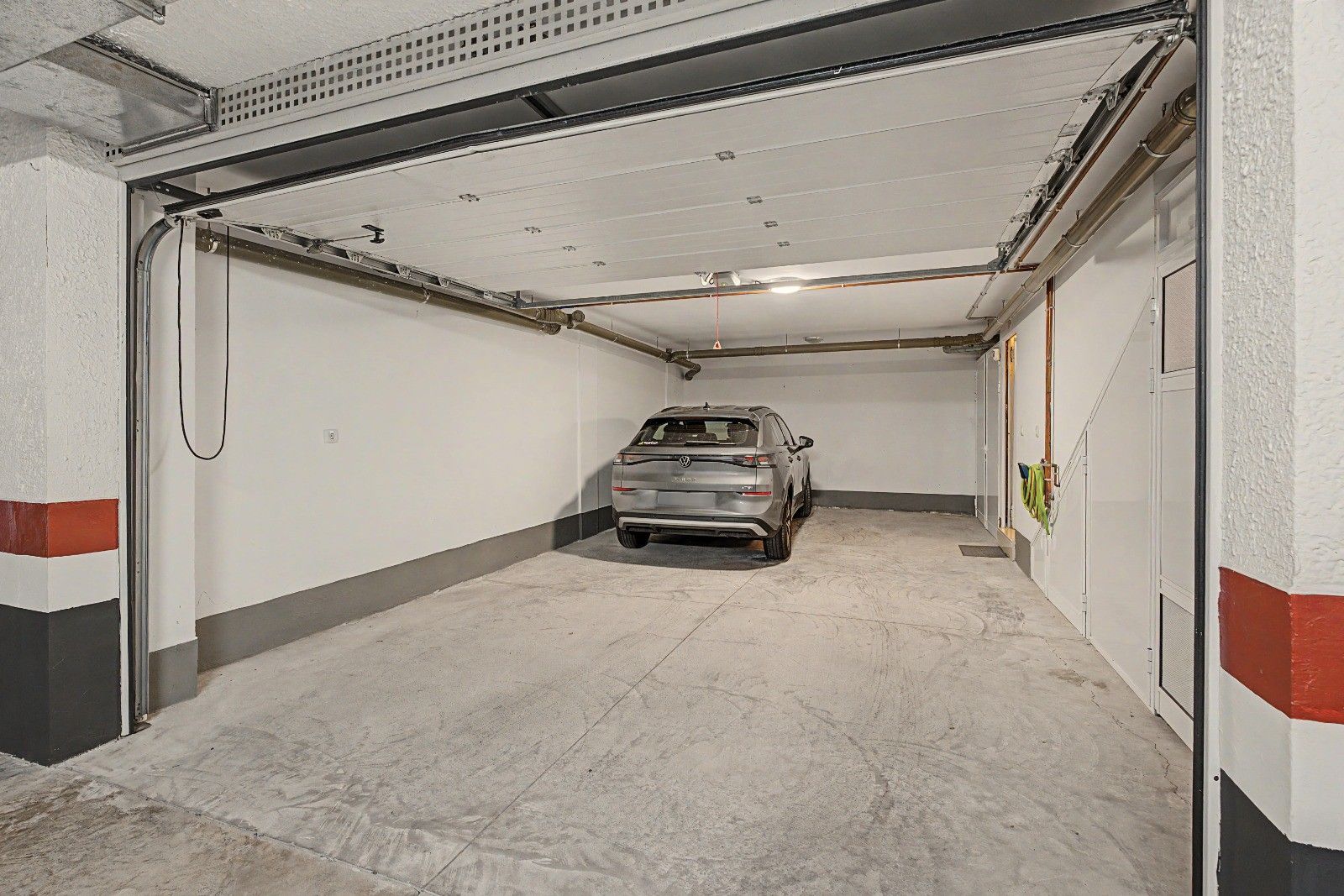 Een parkeergarage met één auto op een parkeerplaats.