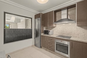 Une cuisine moderne équipée d’appareils électroménagers en acier inoxydable, d’un four à micro-ondes et d’un four encastré.