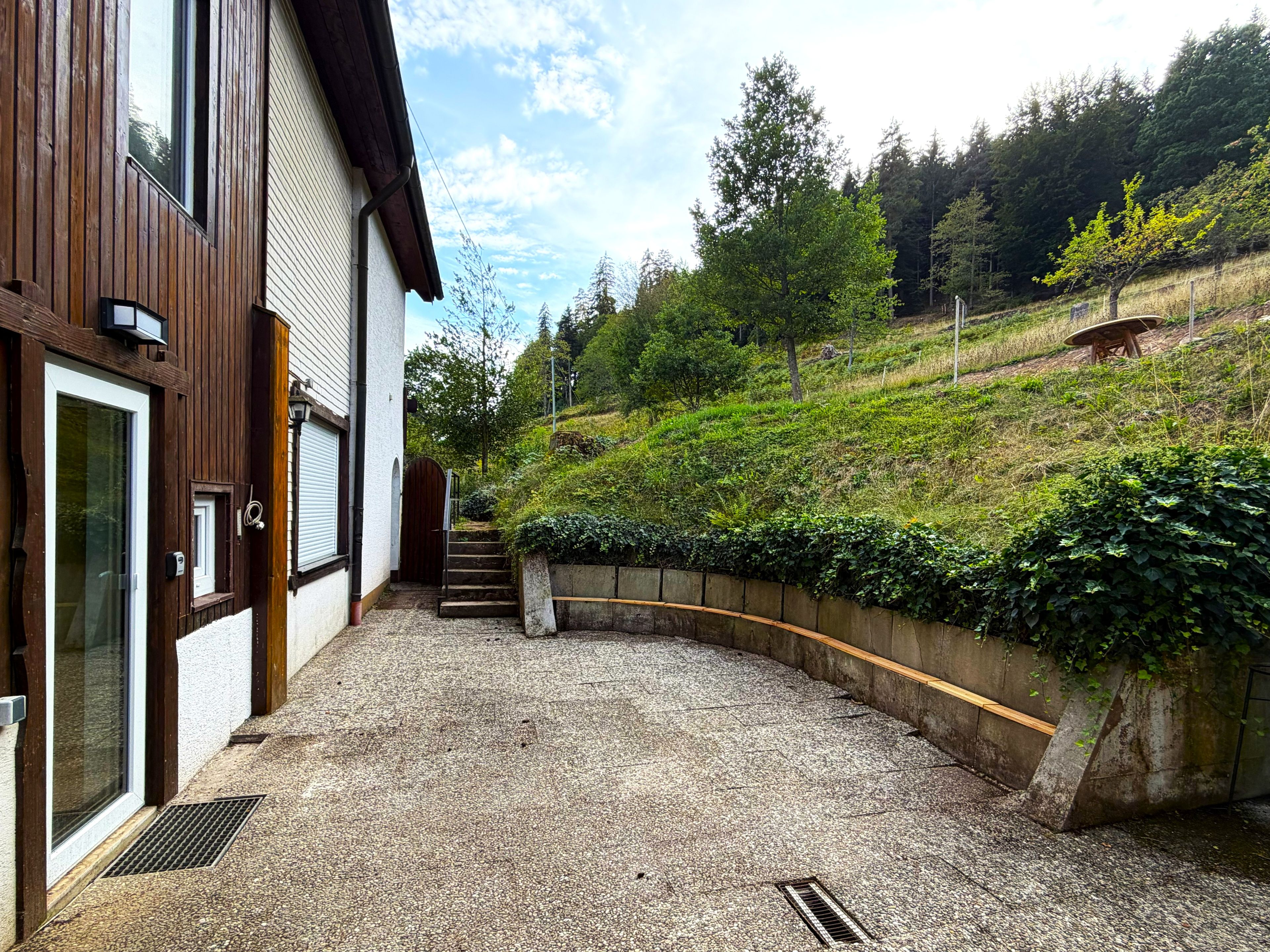 A building with a gravel driveway leading to a wooden staircase.