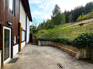 Un bâtiment avec une allée de gravier menant à un escalier en bois.