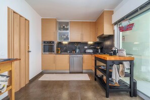 A compact kitchen with wooden cabinets, a dishwasher, and a coffee shop sign. - Madam Butterfly
Delightful 2-bedroom apartment with AC in Faro (Faro)