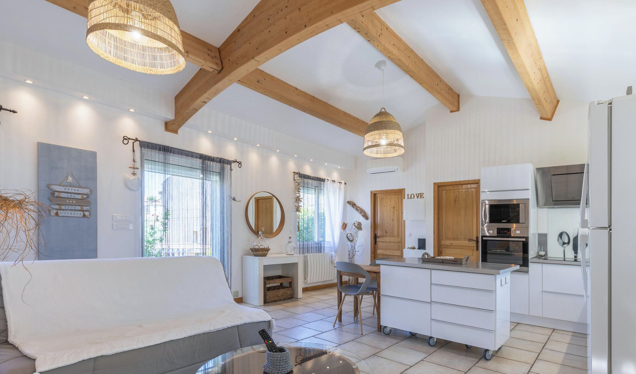 A modern kitchen with white cabinetry, a built-in oven, and a stainless steel refrigerator.