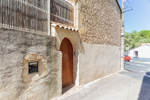 Un edificio con fachada de piedra, puerta de madera y una ventana pequeña.