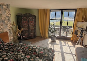 A bedroom with a large bed, a dresser, a potted plant, and a telescope. - Villa with a view of Lake Thiersee (Vorderthiersee)