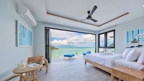 A bedroom with a bed, a desk, a chair, and a balcony with a view of the sea. - "Villa by the Bay" with panoramic view of Samrong Bay and Koh Phangan island. (Chang Wat Surat Thani)