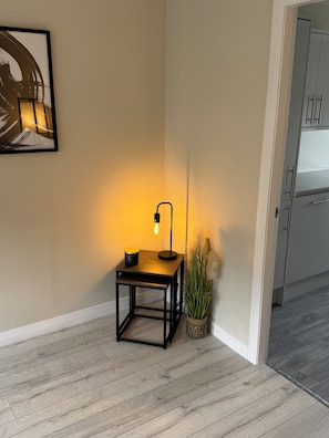 A corner room with a small table, a floor lamp, a potted plant, and a framed artwork on the wall. - Newly Renovated 1 Bedroom Flat In Edinburgh - Sleeps 4 People (Edinburgh)